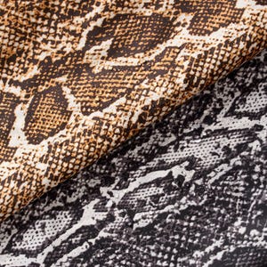 May include: Close-up of two fabrics with a snakeskin pattern. One fabric is brown, tan, and white, while the other is black, white, and gray. The textures are detailed, with a slight sheen.