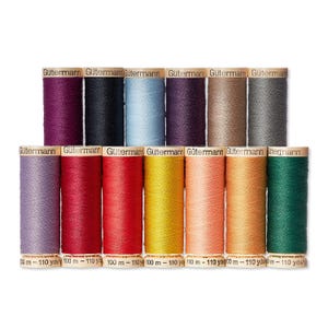 May include: A collection of Gütermann thread spools in various colors, including purple, black, blue, and green. Each spool is labeled with the brand name and measurements of 100 m - 110 yds.