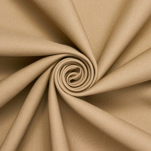 May include: A close-up of a beige fabric with a swirling, spiral pattern. The fabric is smooth and has a subtle texture.