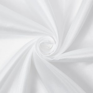 May include: White fabric with a smooth, silky texture, draped and folded to create a swirling pattern.