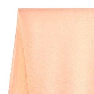 May include: A peach-colored sheer fabric with a smooth, silky texture.
