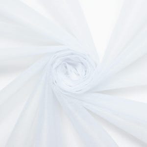 May include: A close-up of a roll of white sheer fabric. The fabric is tightly rolled in the center, with layers of the fabric fanning out. The fabric is translucent and appears to be lightweight.