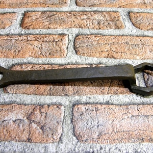 Peut inclure: Une clé à molette rouillée avec une tête hexagonale et une tête de clé à l'autre extrémité.