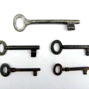 May include: Five antique keys with different shapes and sizes. The keys are made of metal and have a worn, aged appearance.