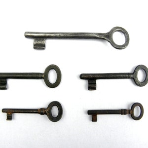 May include: Five antique keys with different sizes and shapes. The keys are made of metal and have a worn, aged appearance. Some keys have a rusty finish.