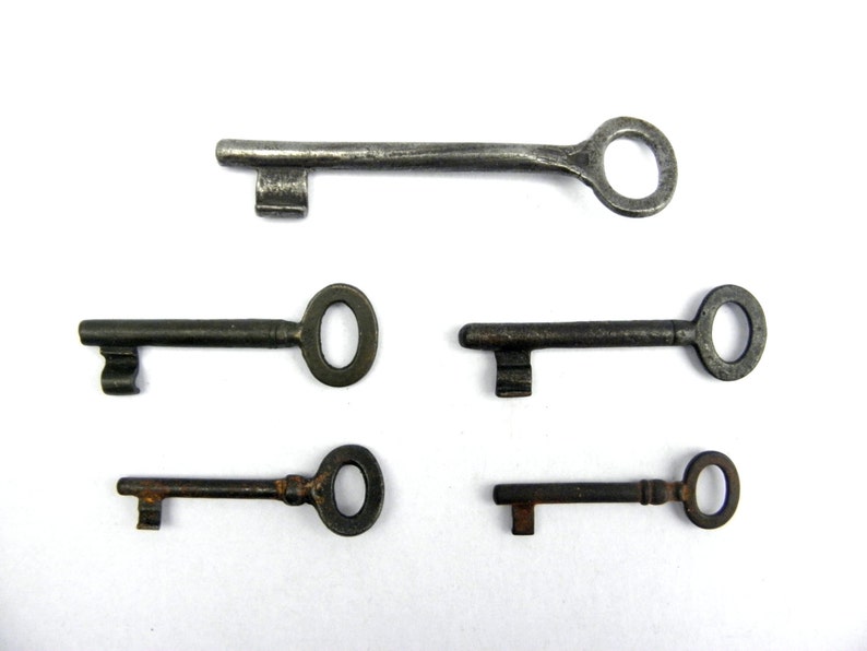 May include: Five antique keys with different sizes and shapes. The keys are made of metal and have a worn, aged appearance. Some keys have a rusty finish.