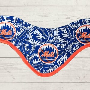 Può includere: Un bandana blu e arancione con un motivo ripetuto di palline da baseball bianche con la scritta "Mets" su di esse.