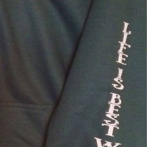 May include: Dark green hoodie with a white paw print graphic inside a circle that reads "LIFE IS BEST WITH A DOG." The sleeve has the text "LIFE IS BEST WITH A DOG" printed vertically in white.