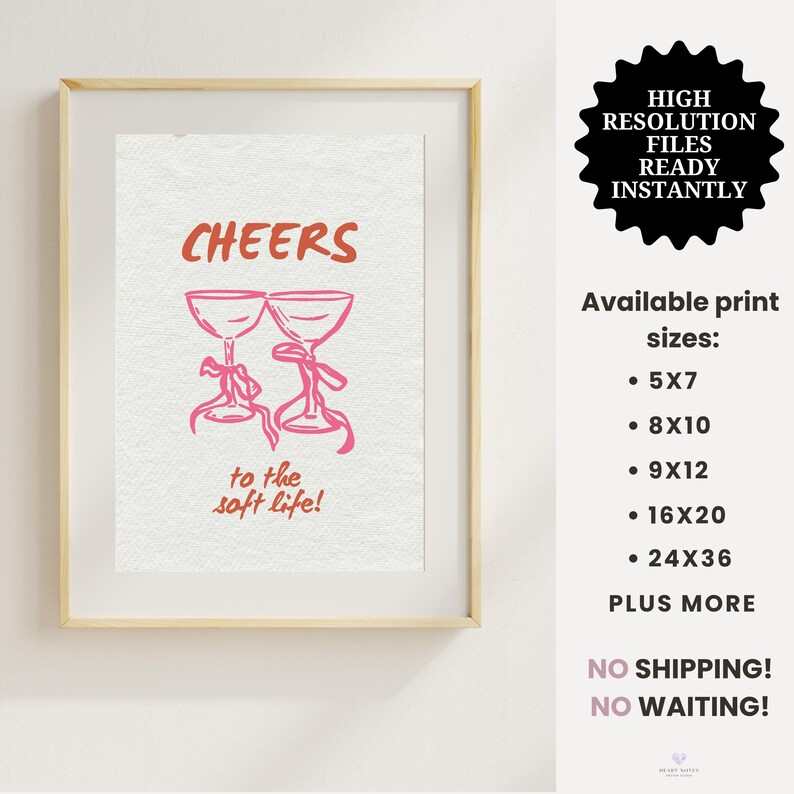 Digital wall art with pink illustrated champagne glasses and red text that says “Cheers to the soft life!” on a textured cream background.