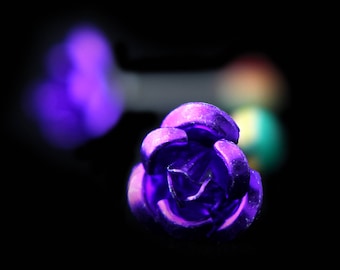 May include: A close-up of a purple metal rose. The rose is a decorative element and has a shiny finish.