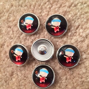 May include: Six silver-toned snap buttons with a cartoon image of a basketball player wearing a red jersey and a blue headband. The player is holding a basketball and has the number 23 on the jersey.