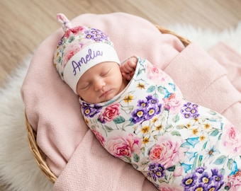 Set fasciatoio floreale rosa e lilla con cappellino con nodo in cima e nome ricamato.