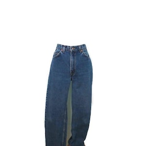 Puede incluir: Un par de vaqueros clásicos de mezclilla azul. Los vaqueros tienen una cintura alta, una pernera recta y un diseño tradicional de cinco bolsillos. La mezclilla es de lavado medio y los vaqueros parecen estar en buen estado.