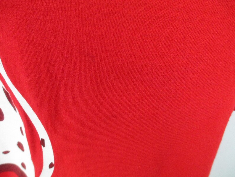 Pu&ograve; includere: Tessuto rosso con un design bianco e nero. Il design &egrave; un'immagine stilizzata di un dalmata.