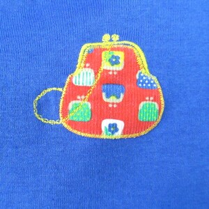 May include: A red, blue, and green patchwork purse with a gold chain, embroidered on a blue fabric.