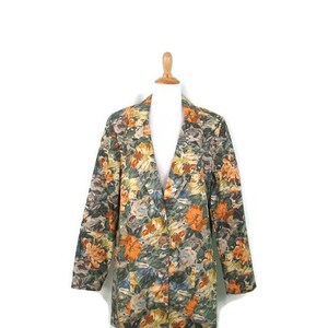 May include: A long-sleeved blazer with a floral print in shades of orange, green, and blue. The blazer has a notched collar and a single button closure.