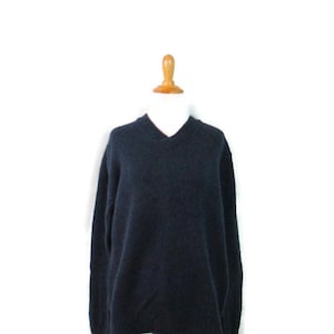 May include: A dark blue v-neck sweater with long sleeves.