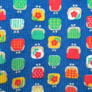 May include: A blue fabric with a repeating pattern of colorful purses. The purses are in various colors, including red, yellow, green, and white. The purses have different designs, including polka dots, stripes, and flowers.