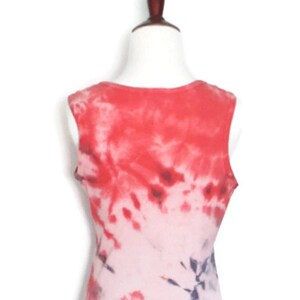 May include: Red, white and blue tie-dye sleeveless tank top. The tank top is a light pink colour with red and blue tie-dye swirls.