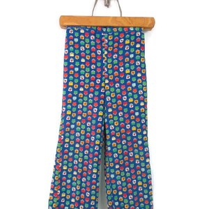 May include: Blue pants with a colorful geometric pattern. The pattern features small squares with red, yellow, green, and white accents.