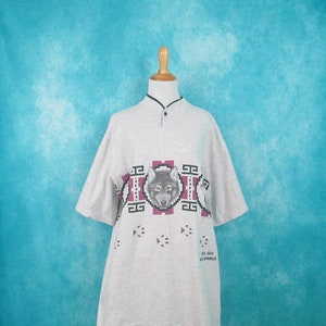 Op de afbeelding: Een grijs shirt met korte mouwen met een wolf-print en een ontwerp ge&iuml;nspireerd op de Amerikaanse indianen. Het shirt heeft een knoopsluiting en de tekst "Sol Duc Hot Springs" staat onderaan gedrukt.