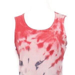 May include: Red and white tie-dye tank top with a scoop neck. The tank top has a faded look with a darker red colour at the top and a lighter white colour at the bottom.