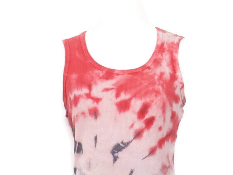 May include: Red and white tie-dye tank top with a scoop neck. The tank top has a faded look with a darker red colour at the top and a lighter white colour at the bottom.