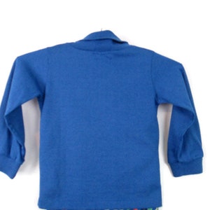 May include: A long-sleeved, blue shirt with a mock neck collar.