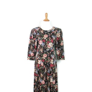 May include: A black floral dress with a round neckline and 3/4 sleeves. The dress has a vintage style and is made of a soft, comfortable fabric.