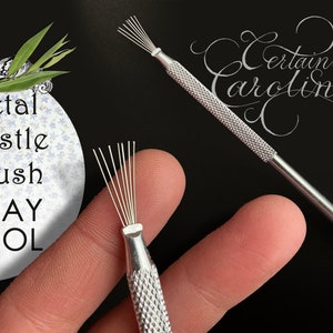 May include: Two metal bristle brushes with a silver finish. The brushes have a textured handle and are used for clay sculpting. The text "Metal Bristle Brush CLAY TOOL" is visible in the image.