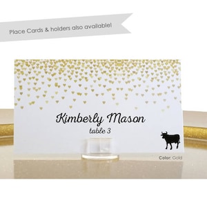 Op de afbeelding: Gouden tafelnummerkaart met een zwart silhouet van een stier en de tekst "Kimberly Mason tafel 3".