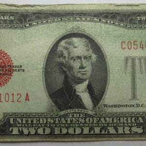 May include: A vintage two dollar bill with a portrait of a man in a suit and tie. The bill is green and has the text "C05461012 A" printed on it.