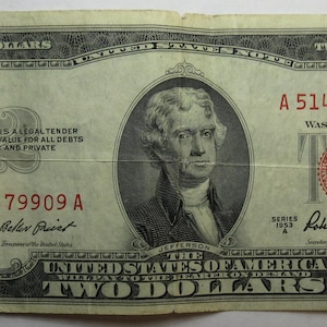 May include: A two dollar bill from the United States of America, featuring a portrait of Thomas Jefferson and the text "This note is legal tender at its face value for all debts public and private." The bill has the serial number A 51479909 A.