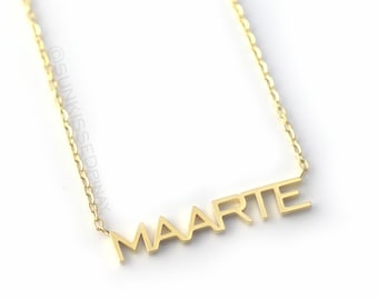 Op de afbeelding: Een gouden ketting met de naam "MAARTE" gespeld in blokletters.