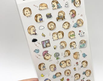 May include: A sheet of Sticker Selection masking tape stickers featuring numerous small, illustrated hedgehogs in various activities, including sleeping, reading, eating, and using umbrellas. The header text reads Sticker Selection.