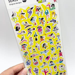 May include: A clear plastic sheet of Mind Wave Seals Original designs by Ochame Club featuring numerous small, colorful cartoon stickers on a bright yellow background. The stickers depict various figures in diverse poses, activities, and outfits, including dancing, eating, and relaxing, with some text elements like OOPS and LOVE.