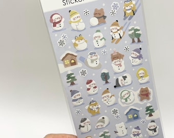 May include: A sheet of Sticker Selection stickers featuring various winter-themed illustrations including snowmen, brown bears, foxes, small houses, pine trees, and snowflakes. The stickers are arranged on a light blue background with Made in Japan text.