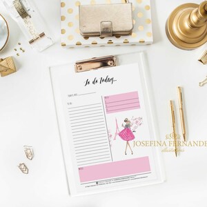 May include: A white clipboard with a pink to-do list titled "To do Today..." with a pink and white striped dress illustration of a woman standing in front of the Eiffel Tower. The clipboard has a gold clip.