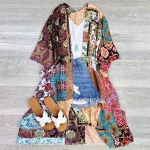 Puede incluir: Un kimono estampado multicolor con un top blanco sin mangas, pantalones cortos de mezclilla y sandalias blancas. El kimono tiene un dise&ntilde;o de patchwork con varios patrones florales y geom&eacute;tricos.