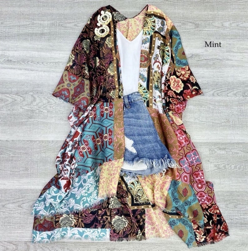 Puede incluir: Un kimono largo multicolor con un dise&ntilde;o de patchwork. El kimono tiene una variedad de patrones florales y geom&eacute;tricos en tonos de rojo, azul, verde, amarillo y marr&oacute;n. La palabra "Mint" est&aacute; escrita en texto blanco sobre un fondo blanco en la esquina superior derecha de la imagen.