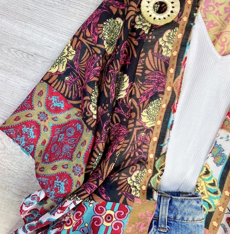 Puede incluir: Un kimono colorido con un patr&oacute;n floral y una parte superior blanca debajo. El kimono tiene un patr&oacute;n marr&oacute;n, rojo, azul y amarillo.