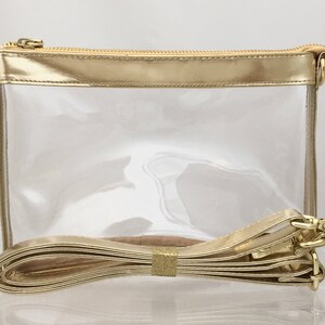 Puede incluir: Un bolso cruzado transparente con cremallera, ribete y correa dorados. El bolso tiene forma rectangular e incluye una correa desmontable. Una etiqueta est&aacute; adherida al bolso. Medidas: aproximadamente 20 cm x 15 cm x 6 cm.