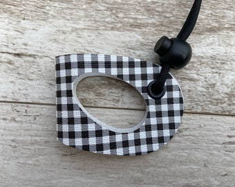 May include: Black and white checkered fabric dog leash handle with a black cord and a black toggle clip.