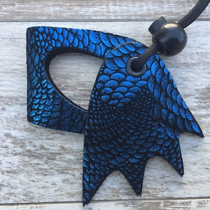 May include: Blue and black leather dragon scale keychain with a black cord and a black toggle clasp.