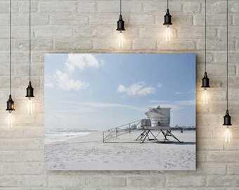 May include: A white lifeguard stand with the number "5" on the side, on a sandy beach with blue sky and white clouds in the background.
