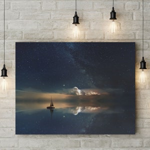 May include: A canvas print of a sailboat on a calm body of water with a starry night sky and a reflection of the stars in the water.