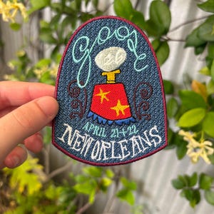 May include: Embroidered patch with the word "goose" in cursive, a stylized image of a goose, and the text "April 21+22 New Orleans." The patch has a blue background with red and yellow accents.