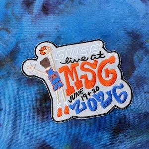 May include: An embroidered patch featuring a basketball player in a blue jersey with the number 26, holding a basketball. The text reads GOOSE live at MSG JUNE 19+20 2026 in orange, blue, and white thread on a light gray background with a black border.