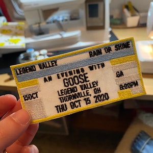 May include: A yellow and blue embroidered patch with the text "LEGEND VALLEY", "AN EVENING WITH GOOSE", "LEGEND VALLEY", "THORNVILLE, OH", "THU OCT 15 2020", "RAIN OR SHINE", "150CT", "GA", and "8:00PM".