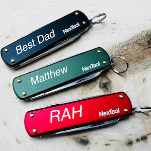 May include: Three multi-tools in black, green, and red, each with a silver key ring. The black tool reads "Best Dad", the green tool reads "Matthew", and the red tool reads "RAH". Each tool has the "Nextool" logo.